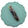 Détail du pendentif hexagonal en cristal violet avec design enveloppé de fil doré - Améthyste