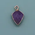 Detailed macro view of faceted purple gemstone shield pendant with a gold plated edge - Shield Shape Pendant (1003-T250705018) / Purple Crystal