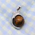 Detail of dolphin shaped silver pendant holding a polished natural tiger eye stone bead - 14x23mm / Tiger's Eye