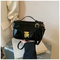 Elegante borsa a mano in pelle verniciata nera con chiusura in metallo dorato e tracolla - Nero
