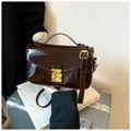 Dark brown patent leather handbag with gold metallic clasp and adjustable shoulder strap - Brown
