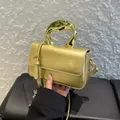 Metallic gold crossbody bag with unique wave handle and adjustable leather strap - Gold