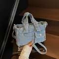 Light blue washed denim crossbody bag in retro biker style with silver buckle details - Light Blue