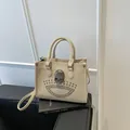 Beige tote bag with silver skull ornament and metallic studs, top handle crossbody style - Khaki