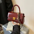 Burgunderrote Vintage Handtasche aus Kunstleder mit goldenem Verschluss und Anhänger - Rot mit Anhänger