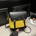 Mochila retro en contraste de cuero negro y ante amarillo con detalles de hebilla dorada - Amarillo