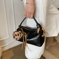 Retro black leather pillow bag with bold gold ring handle and leopard pompom charm - Black PU With Charm