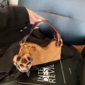 Vintage brown suede and leather handbag with leopard heart charm on a chair - Suede Light Brown With Charm