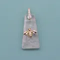 Macro detail of trapezoid rose quartz pendant featuring a gold bee and pavé zircon clasp - Rose Quartz