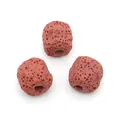 Macro shot of three porous reddish-brown lava stone beads with center holes for DIY jewelry - Reddish Brown