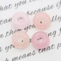 Macro-opname van vier ronde donuts van natuurlijk rozenkwarts met gepolijste textuur - Rozenkwarts