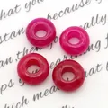 Macro-opname van vier rozerode stenen kralen met groot gat voor DIY-sieraden maken - Rozerode Chalcedoon