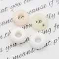 Detalle macro de cuatro cuentas de piedra natural con agujero grande para joyería artesanal - 10x10mm / Jade Blanco