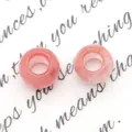 Dettaglio macro di due perle di agata rosa traslucida con fori grandi per gioielli DIY - Quarzo Cocomero