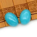 Detailopname van levendige blauwe ovale turquoise cabochons op een bamboemat oppervlak - Teal
