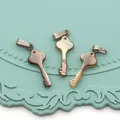 Vue détaillée de trois pendentifs en nacre naturelle en forme de clé à reflets irisés - En Forme de Clé / 9x24mm / Arc-en-ciel