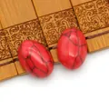 Twee ovale rode turquoise kralen met zwarte aders op een bamboe houten dienblad - Rode Netwerkjaspis