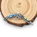 Macro detail of revolver pistol pendant with abalone shell inlay and floral engraving - Revolver Shape / 32x64mm