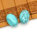 Twee ovale turquoise stenen met donkere netpatronen op een vintage bamboemat - Blauwe ader turkoois