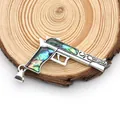 Detailed view of pistol pendant with abalone shell inlay on a natural wood surface - Pistol Shape / 35x56mm