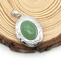 Detail of floral engraved oval locket pendant featuring a green stone inlay on wood - Oval Green Aventurine