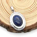 Detail view of a vintage oval locket pendant with blue lapis lazuli on a wooden base - Oval Lapis Lazuli