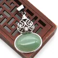 Macro view of a hollow-patterned silver pendant with green malachite stone inlay - Green Aventurine