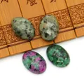 Ovale robijn in zoisiet cabochon edelstenen voor DIY sieraden op bamboe achtergrond - Robijn Zoisiet