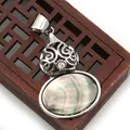 Close-up of vintage gourd pendant with hollow metal frame and iridescent shell inlay - Black Mother of Pearl