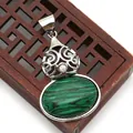 Detail of green malachite stone pendant with silver filigree on a vintage wooden box - Malachite