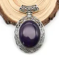 Macro detail of oval purple gemstone pendant with silver filigree on a wooden base - 47x73mm / Purple Agate