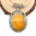 Macro detail of oval yellow agate pendant with hollow silver zinc alloy carving - 47x73mm / Topaz