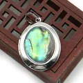 Macro view of oval locket pendant with rainbow abalone shell and vintage hinge detail - Oval (25x33)