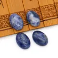 Set van vier ovale blauwe natuursteen cabochons met witte aders op bamboe blad - Blauwe spotsteen