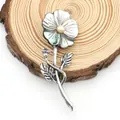 Macro detail of French shell flower brooch with pearl center on wood texture - Iridescent Five-Petal Flower Style (No. 2)