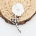 Macro detail of natural shell flower brooch with pearl center and vintage silver leaf - White Mother of Pearl Style