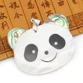 Detailed view of handmade panda pendant made of white shell and abalone on bamboo background - Panda Style