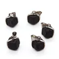 Macro detail of five square black lava stone pendants with silver-plated frames and edges - 17x18mm