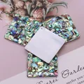 Détail macro de pendentifs carrés en mosaïque d'abalone et nacre pour la création de bijoux - Losange