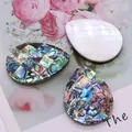 Gros plan de pendentifs en nacre d'abalone et de breloques mosaïque pour bijoux artisanaux - Larme