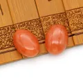 Paar ovale oranje-rode carnelian agaat cabochon stenen op traditionele bamboe achtergrond - Oranje Carneool