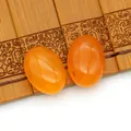 Gepolijste amberkleurige ovale agaat cabochons voor DIY sieraden op bamboe mat - Oranje Agaat