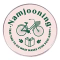 Spilla Namjooning rosa con illustrazione di bicicletta verde e libro su fondo bianco - Bianco latte