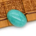 Gepolijste ovale turquoise cabochon voor DIY sieradenringen op een bamboemat - Hemelsblauw