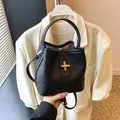 Minimalist black bucket bag in lychee pattern leather with a gold metal twist lock - Black