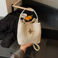 Off-white lychee texture bucket bag with gold twist lock and detachable strap - White
