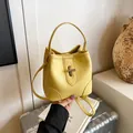 Bright yellow bucket bag with lychee texture and metallic twist lock for women - Yellow