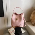 Pink lychee grain leather bucket bag with elegant gold T-clasp and shoulder strap - Pink