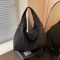 Large black minimalist tote bag in nylon fabric for women on stylish desk display - Black