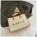 Stijlvolle crème geweven tote bag met bruine lederen bies en Paris-tekst met schouderriem - Groot Beige & Khaki